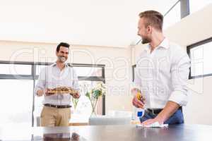 Smiling gay couple cleaning living room