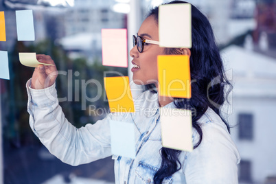 Asian woman removing sticky notes