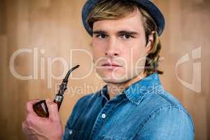 Serious hipster holding pipe