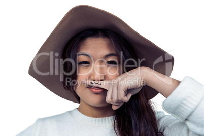 Asian woman with mustache on finger posing for the camera