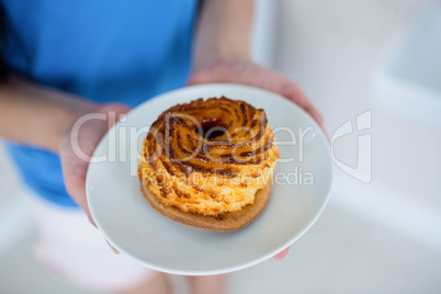 Young woman in blue holding pastry