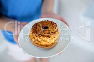 Young woman in blue holding pastry