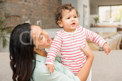 Smiling brunette playing with her baby