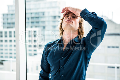 Troubled hipster businessman holding his head