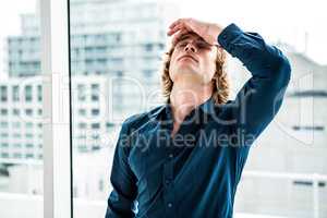 Troubled hipster businessman holding his head
