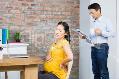 Suffering pregnant woman sitting on chair