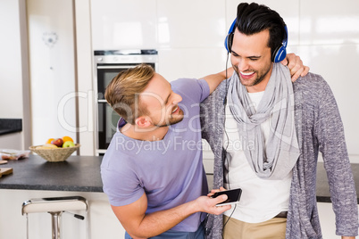 Smiling gay couple listening to music