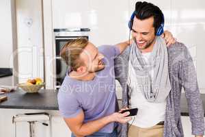 Smiling gay couple listening to music