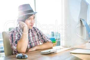 Worried hipster businessman using computer