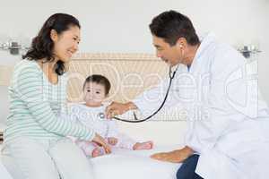 Cute baby being visited by doctor