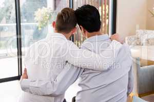 Rear view of gay couple with arms around