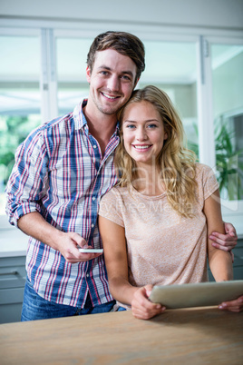 Cute couple using tablet computer in the kitchen