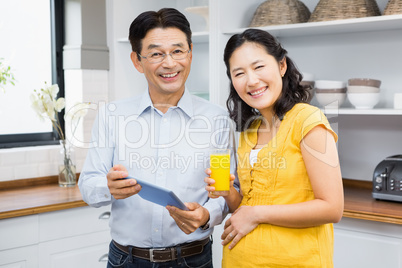 Happy expectant couple using tablet