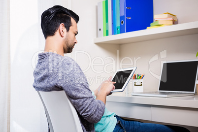 Busy man using tablet and laptop
