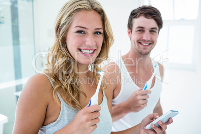 Young couple brushing their teeth at home