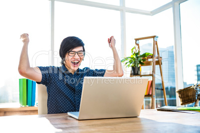 Cheerful asian businessman using laptop