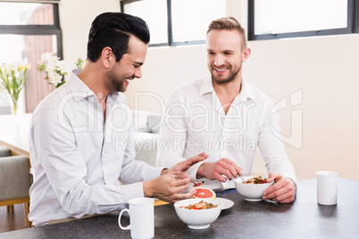 Smiling gay couple having breakfast