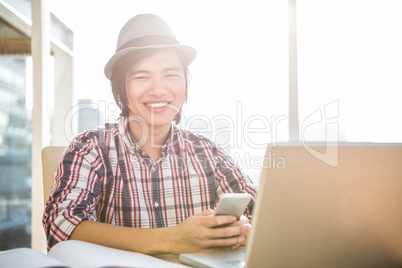 Smiling hipster businessman using smartphone