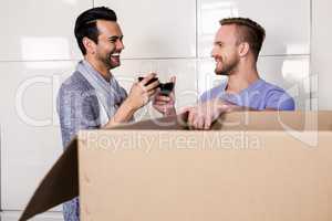 Smiling gay couple drinking red wine