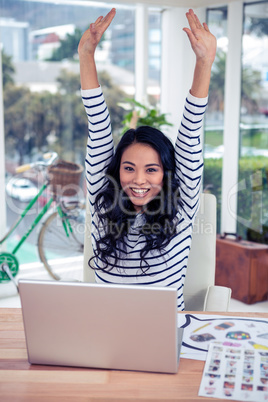 Happy Asian woman with arms raised