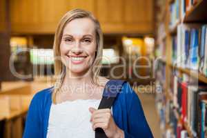 Smiling female student posing in the library