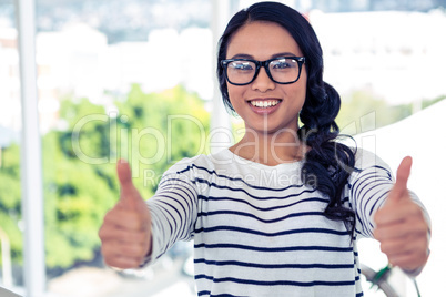 Smiling Asian woman showing thumbs up