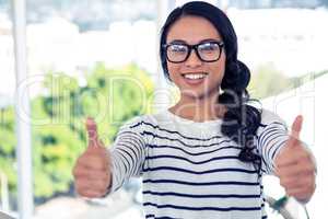 Smiling Asian woman showing thumbs up