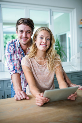 Cute couple using tablet computer in the kitchen