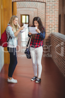 Happy female students looking at results