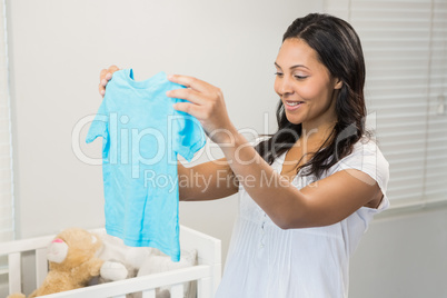 Smiling brunette holding baby tshirt