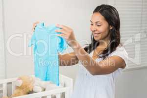 Smiling brunette holding baby tshirt