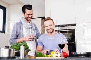 smiling gay couple preparing food