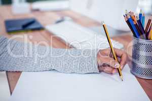 Womans hand drawing with pencil on white sheet