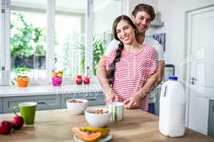 Happy couple standing in kitchen