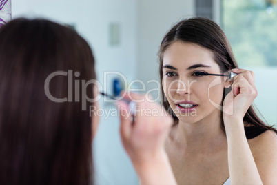 Brunette applying mascara