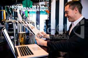 Businessman reading the news and using laptop