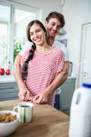 Happy couple standing in kitchen