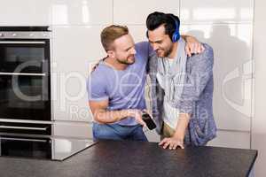 Smiling gay couple listening to music