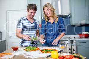 Smiling couple preparing pizza