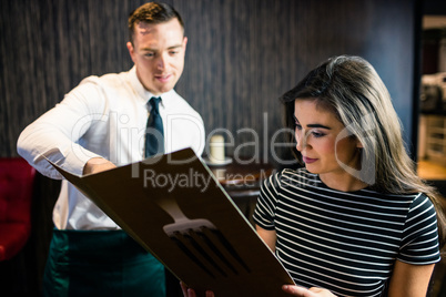 Attractive woman ordering to the waiter from the menu