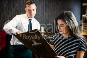 Attractive woman ordering to the waiter from the menu