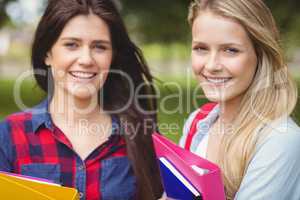Smiling students holding binder