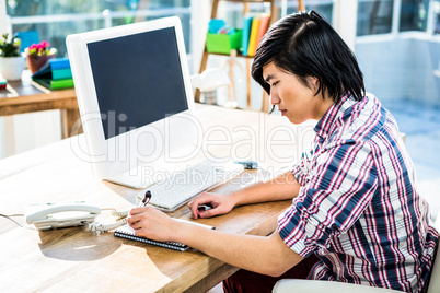 Hipster businessman writing on notebook