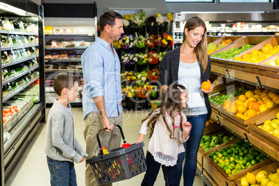 Cute family choosing groceries together