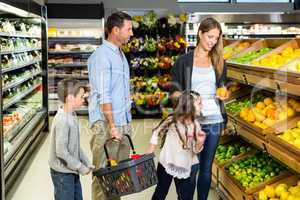 Cute family choosing groceries together