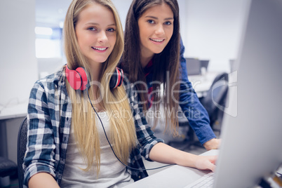 Smiling students using computer