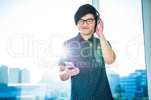 Smiling asian businessman listening to music