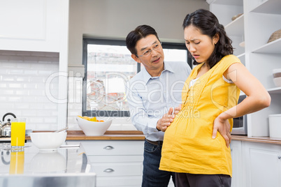 Lovely husband taking care of pregnant wife with back ache