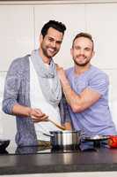 smiling gay couple preparing food