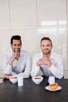 Smiling gay couple having breakfast